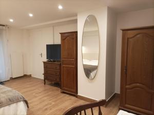ein Schlafzimmer mit einem Spiegel, einem Bett und einer Kommode in der Unterkunft Iris Garden Cottage in Saint-Germain-en-Laye