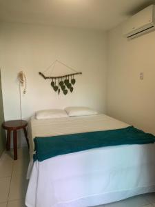 a bedroom with a white bed with green sheets at Chalé Park Mar, São José e Maragogi in São José da Coroa Grande +38 photos