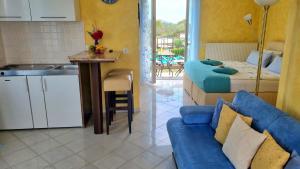 a kitchen and a living room with two beds and a couch at Casa Maichen Olbia in San Pantaleo