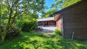 ein Haus mit einem Picknicktisch neben einem Gebäude in der Unterkunft Bramble Bank Gisburn Forest Lodge in Skipton + 10 Fotos