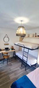 a room with two bunk beds and a desk at CasaZaPatos Bungalows in Nigrán