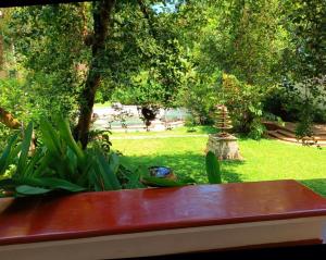 a red bench in a garden with a park at Marari Beach Bungalow Resort Alleppey in Mararikulam