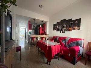 een woonkamer met een rode bank en een tafel bij House in Malaga in Málaga