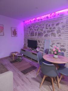 Una sala de estar con una mesa y un televisor. en El susurro del tajo La ermita, en Toledo