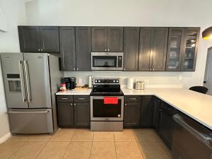 eine Küche mit schwarzen Schränken und Edelstahlgeräten in der Unterkunft Charming Villa with Private Pool 20 min to Disney! in Davenport + 27 Fotos