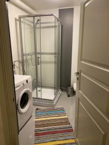 a bathroom with a shower and a washing machine at Solsidan 1 in Karlstad +18 photos