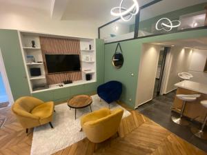 a living room with two chairs and a television at Loft Sud de Paris in Clamart