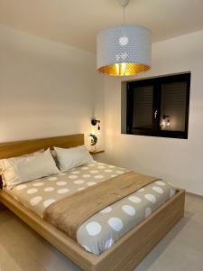 un grande letto in una camera da letto con un lampadario di Demar Apartments a Salerno