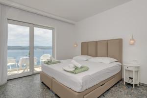 a bedroom with a large bed with towels on it at Deluxe Seaview Studios KENNEDY II in Mimice