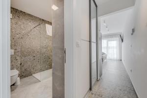 a white bathroom with a shower and a toilet at Deluxe Seaview Studios KENNEDY II in Mimice +85 photos