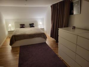 a bedroom with a bed and a dresser with two lamps at Sahlin - Kattarp in Kattarp