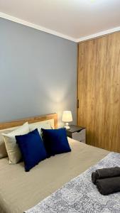 a bedroom with a large bed with blue pillows at Mark House 4 in Căuşeni