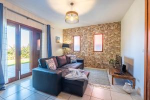 a living room with a couch and a tv at Casa del Mar II by GALMI in Arco de São Jorge +24 photos