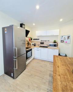 Una cocina grande con refrigerador de acero inoxidable. en Chez Jojo, en Saint-Dizier