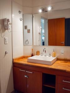 a bathroom with a white sink and a mirror at Dolce Casa Departamentos in Neuquén