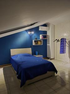 a blue bedroom with a bed and a blue wall at Casa Margherita in Tribiano