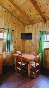 ein hölzernes Esszimmer mit einem Holztisch und Stühlen in der Unterkunft Cabañas Flores de Lapacho Iguazu in Puerto Iguazú + 4 Fotos