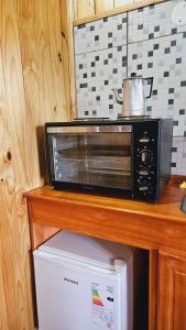 eine Mikrowelle auf einem Kühlschrank in der Unterkunft Cabañas Flores de Lapacho Iguazu in Puerto Iguazú