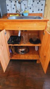 einen Holzschrank mit einem Waschbecken in der Küche in der Unterkunft Cabañas Flores de Lapacho Iguazu in Puerto Iguazú