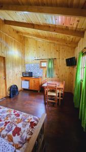 ein Holzzimmer mit einem Tisch und einem Esszimmer in der Unterkunft Cabañas Flores de Lapacho Iguazu in Puerto Iguazú