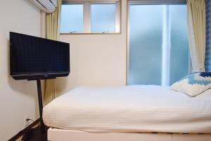 a bedroom with a bed and a flat screen tv at Hostel In Kyoto Gion - Vacation STAY 13366v in Gionmachi