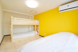 a bedroom with a bunk bed and a yellow wall at Hostel In Kyoto Gion - Vacation STAY 13354v in Gionmachi