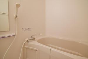 eine weiße Badewanne im Bad mit Spiegel in der Unterkunft Hostel In Kyoto Gion - Vacation STAY 13450v in Giommachi