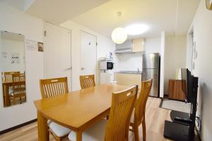 eine Küche und ein Esszimmer mit einem Holztisch und Stühlen in der Unterkunft Hostel In Kyoto Gion - Vacation STAY 13450v in Giommachi