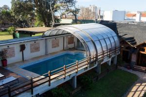 a house with a swimming pool with a glass roof at Lomitas Villa Gesell in Villa Gesell