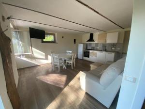 a living room with a white couch and a table at CASCINA BINELLO appartamenti A & B in Belvedere Langhe