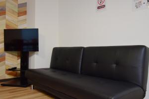 a black couch in a living room with a television at Hostel In Kyoto Gion - Vacation STAY 13400v in Gionmachi
