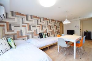 a room with two beds and a table and chairs at Hostel In Kyoto Gion - Vacation STAY 13388v in Gionmachi