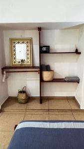 a bedroom with a mirror and shelves and a bed at Casa Eulogia y Fortunata con AC y Desayuno a pasos del mar in Zipolite