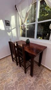 a wooden table and chairs in a room with a window at Casa Eulogia y Fortunata con AC y Desayuno a pasos del mar in Zipolite +43 photos