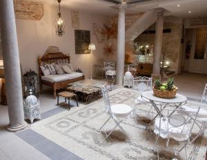sala de estar con sofá, mesa y sillas en Palacio Almagra, en Granada