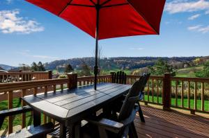 a wooden table with a red umbrella on a deck at Family Friendly Spacious Townhome Across From Holiday Valley in Ellicottville