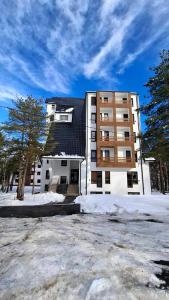 um grande edifício com neve em frente em Divcibarski Izvor Apartman 12 em Divčibare