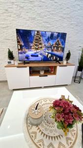 uma sala de estar com televisão num centro de entretenimento branco em Divcibarski Izvor Apartman 12 em Divčibare