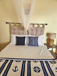 a bed with blue and white pillows on it at STUDIO Azur in Gourbeyre
