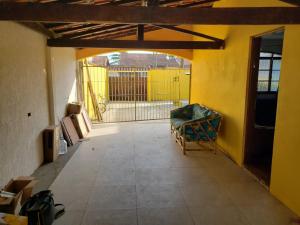 an empty room with a yellow wall and a chair at Casa grande para temporada in Itanhaém