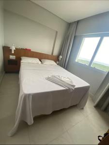 a white bed in a room with a window at Salinas Exclusive Resort in Salinópolis