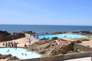 a group of people swimming in pools at the beach at Santiago Beach House in Leça da Palmeira