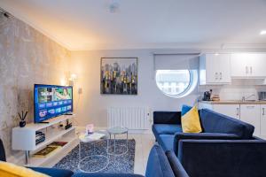 uma sala de estar com um sofá azul e uma TV em Eyre Arch Rest em Galway