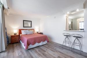 a bedroom with a bed and two stools at Royal Garden Waikiki - Ocean View - Resort Amenities in Honolulu +23 photos
