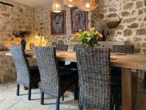 ein Esszimmer mit einem Holztisch und Stühlen in der Unterkunft Chambre d'hôte Les Oulies Bédoin in Bédoin