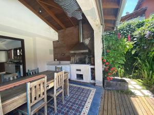 an outdoor kitchen with a table and a stove at Casa Conforto Barra do Una in São Sebastião
