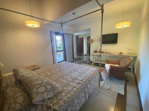 a bedroom with a bed and a desk and a television at Casa Conforto Barra do Una in São Sebastião