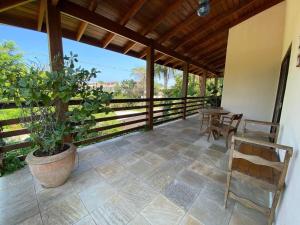 a porch with a table and chairs and a potted plant at Casa Conforto Barra do Una in São Sebastião +68 photos
