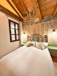 a bedroom with a large white bed in a room at La Casita de La Nozal de la Peña in Villaviciosa