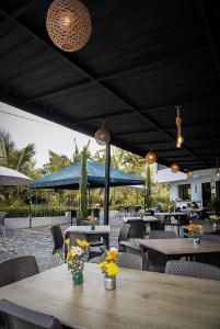 a patio with tables and chairs with flowers on it at Cielo Blue Hotel Boutique in El Peñol